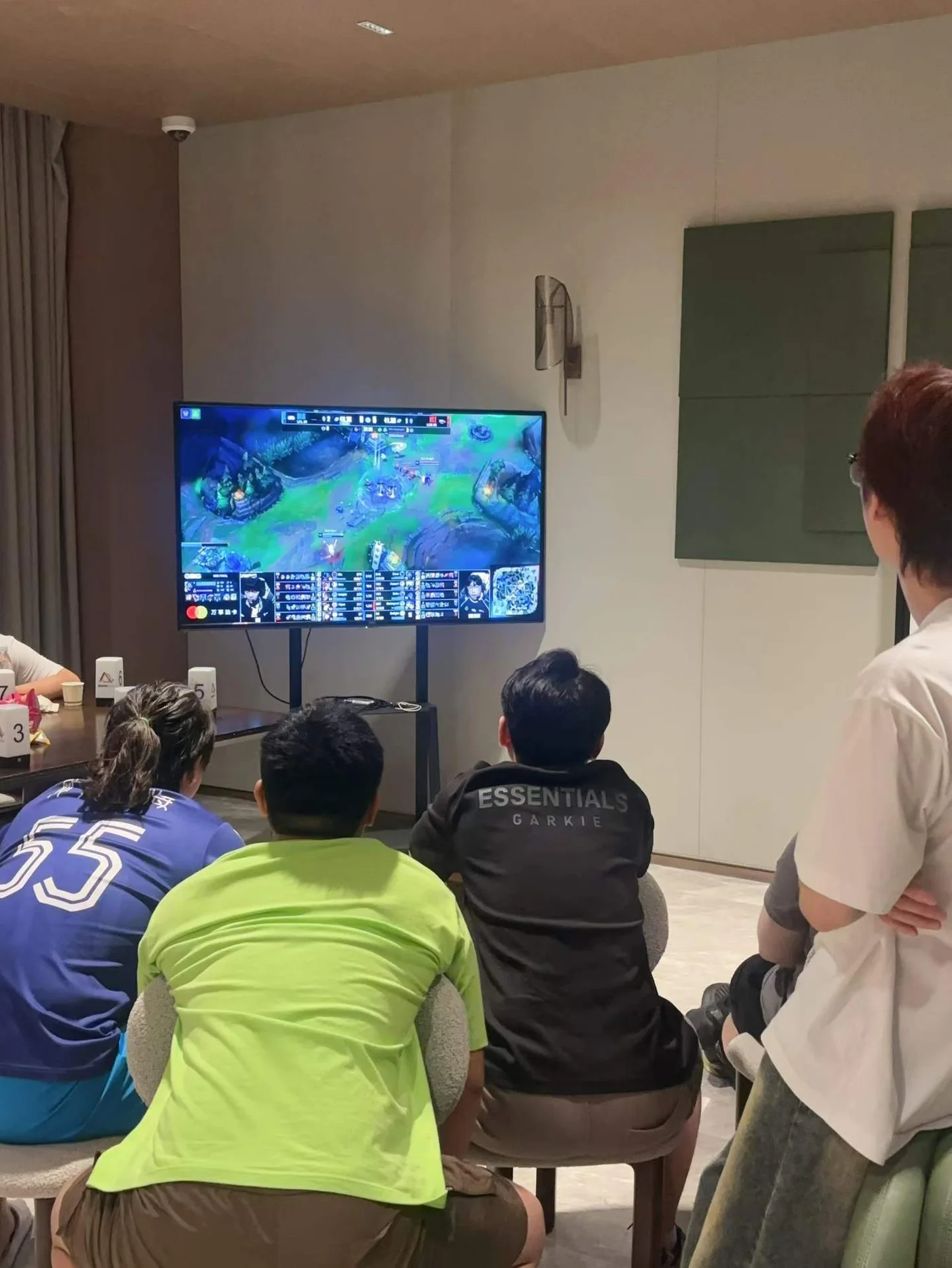 朋友们一起看屏幕上的电竞比赛