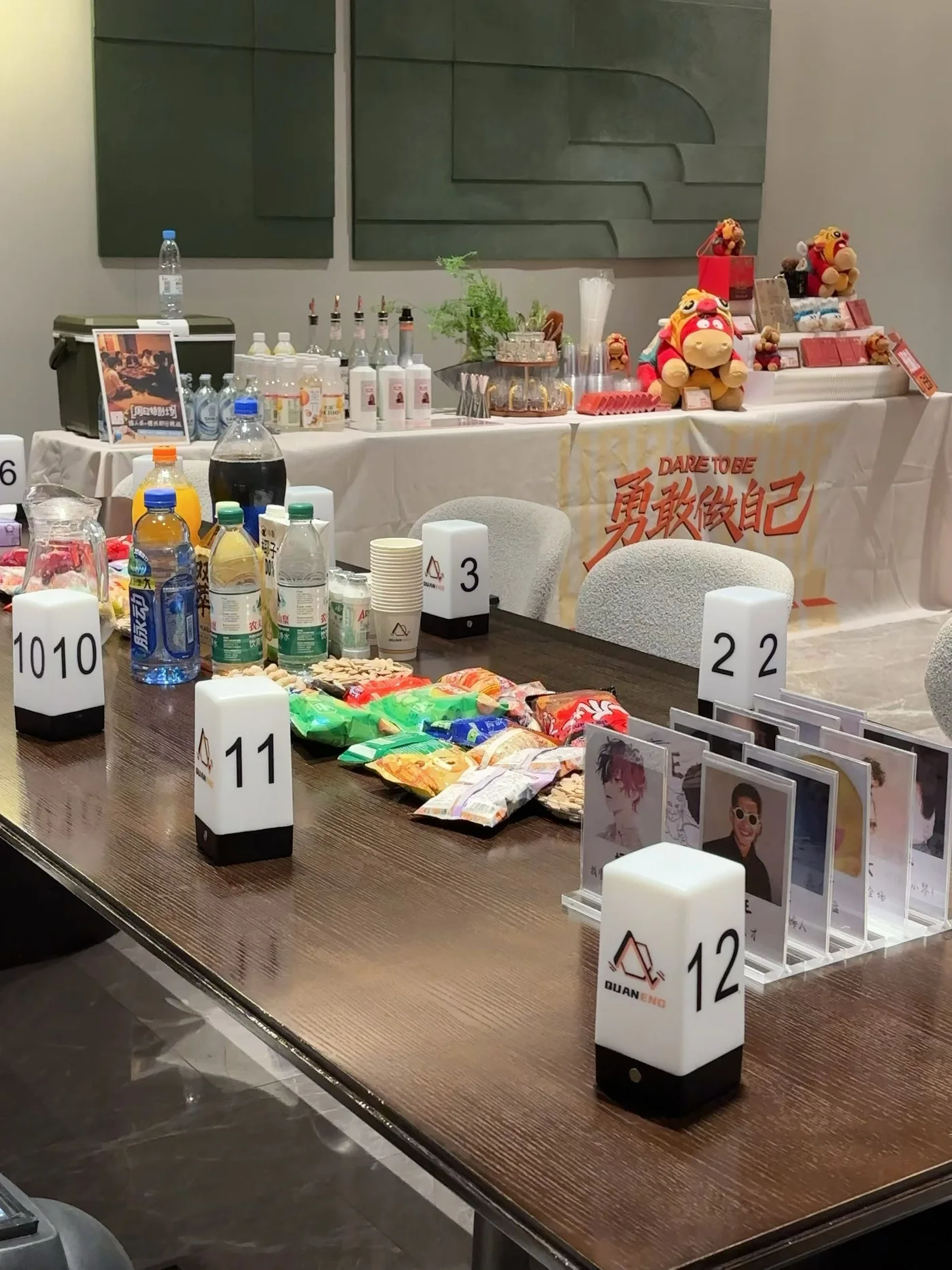 桌上摆着零食、饮料、角色牌和发光号码牌